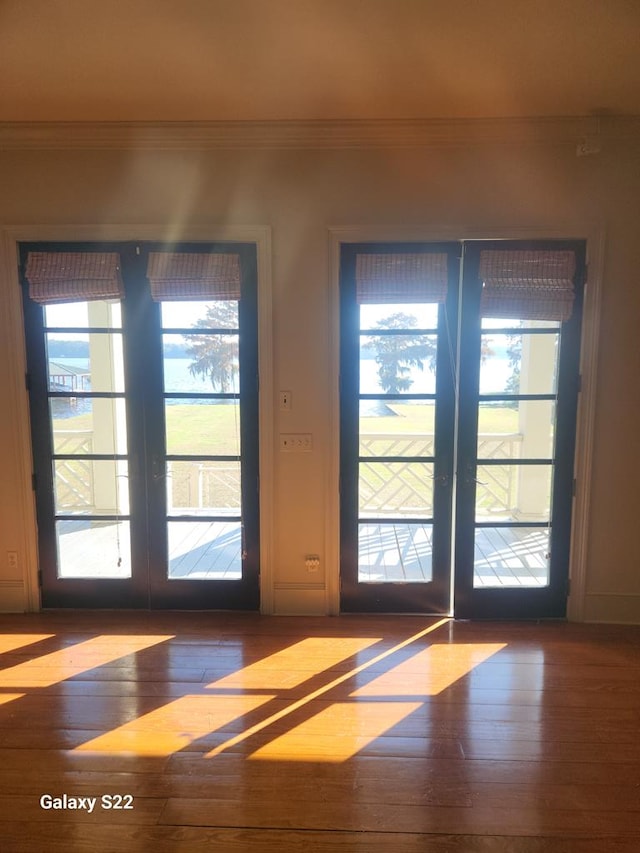 entryway with crown molding, dark wood-type flooring, and french doors