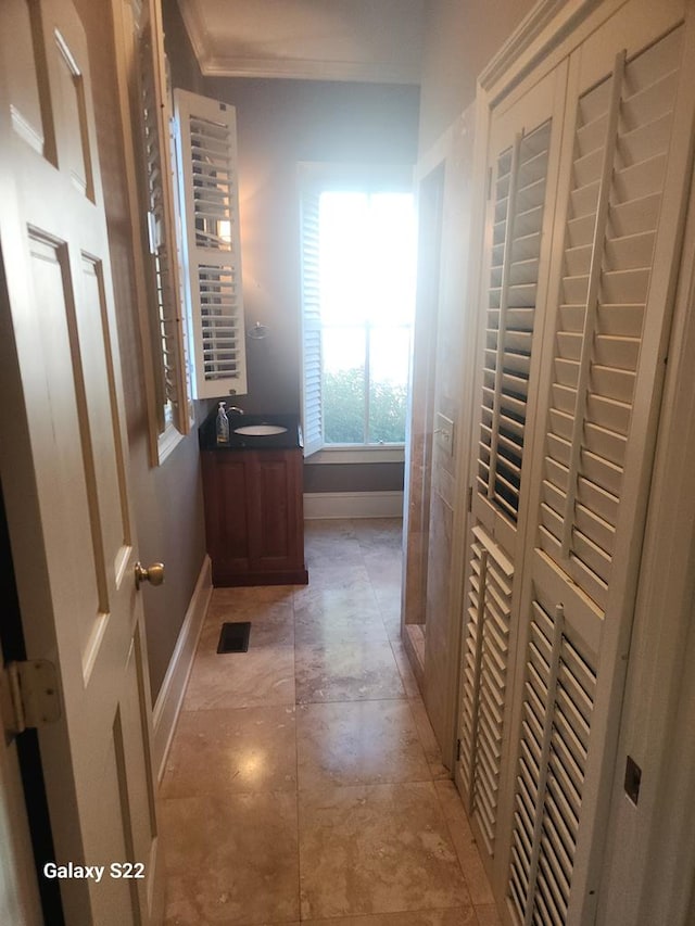 hallway featuring sink and ornamental molding