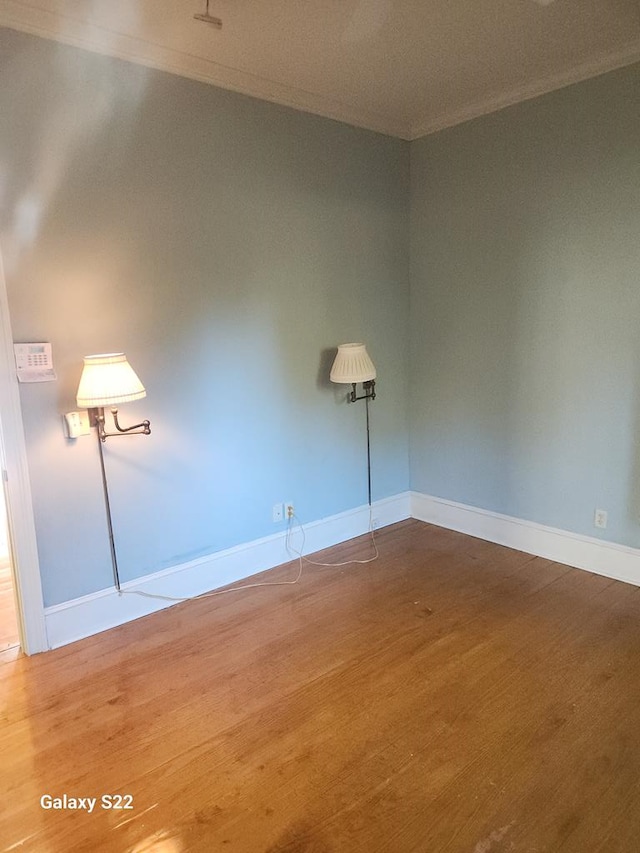 unfurnished room with wood-type flooring and ornamental molding