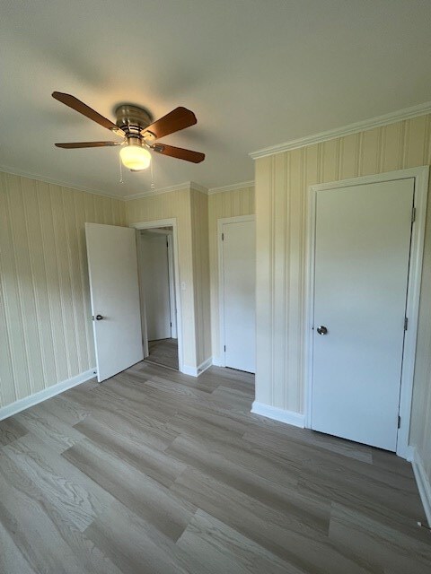 510 E 25th Ave, Cordele, GA 31015 - unfurnished bedroom featuring ornamental molding, baseboards, wood finished floors, and ceiling fan