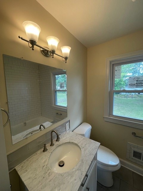 510 E 25th Ave, Cordele, GA 31015 - bathroom featuring healthy amount of natural light, tile patterned flooring, vanity, toilet, and lofted ceiling