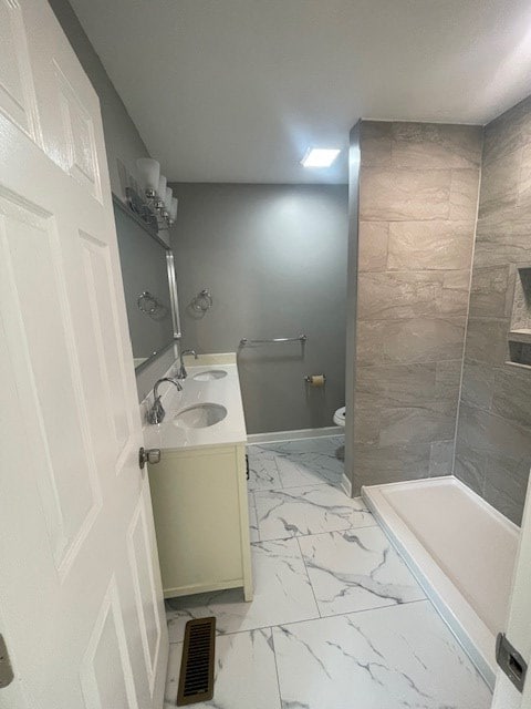 510 E 25th Ave, Cordele, GA 31015 - full bathroom featuring marble finish floors, toilet, vanity, a shower, and baseboards