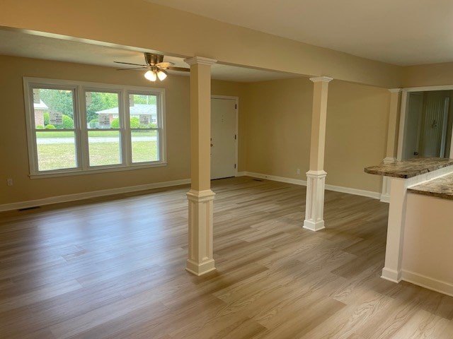 510 E 25th Ave, Cordele, GA 31015 - unfurnished living room with decorative columns, baseboards, light wood finished floors, and ceiling fan