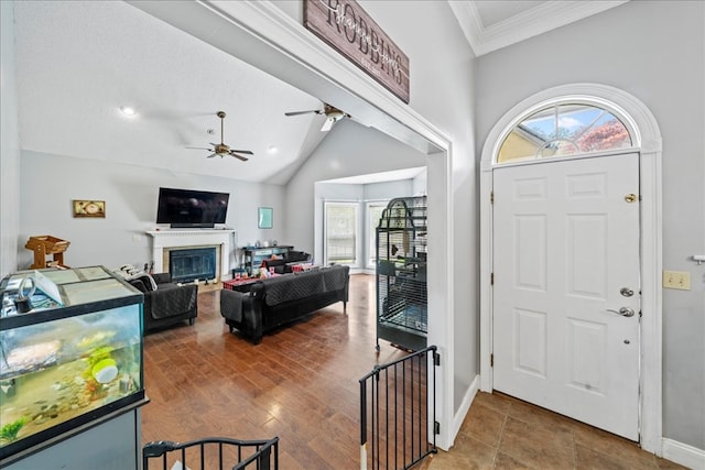 entrance foyer featuring crown molding, ceiling fan, a textured ceiling, and lofted ceiling