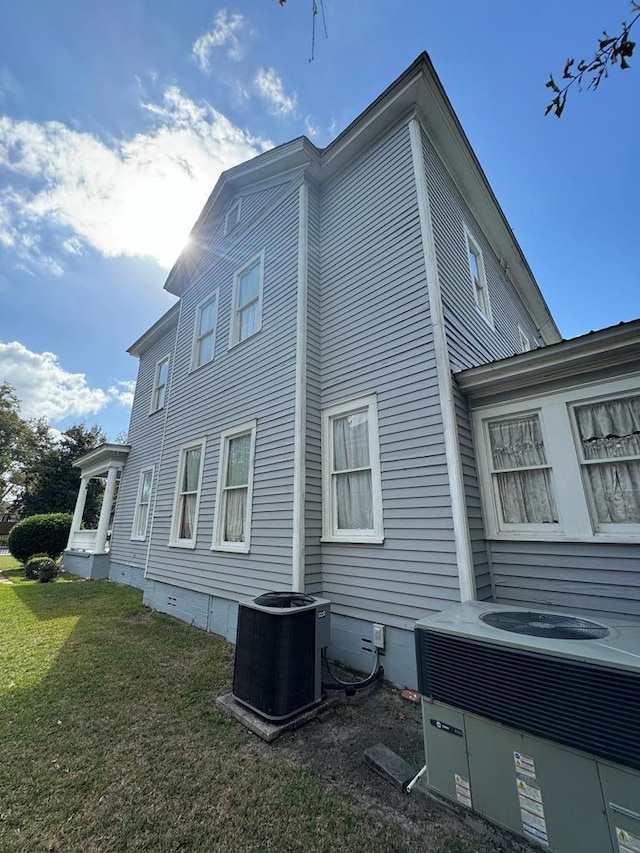 view of home's exterior featuring central AC unit and a lawn