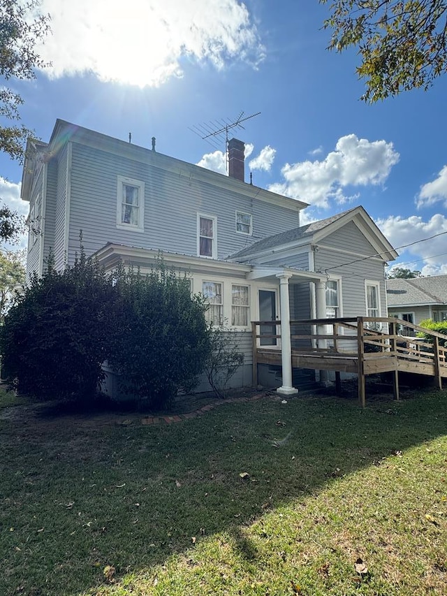 back of house with a lawn and a wooden deck