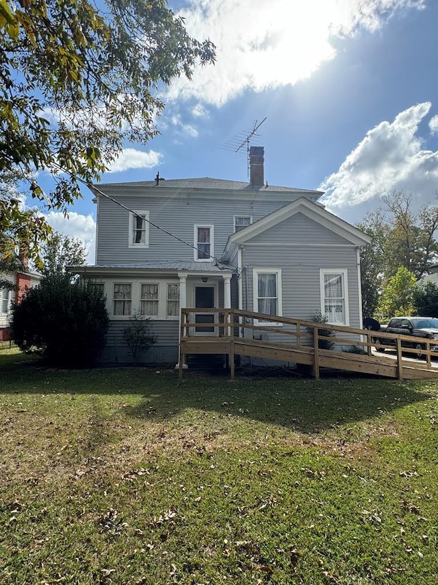 rear view of house with a wooden deck and a yard