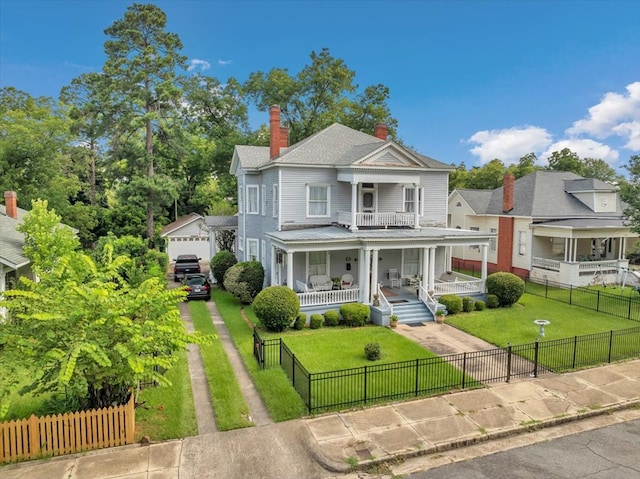 view of front of house featuring a porch, a garage, and a front yard