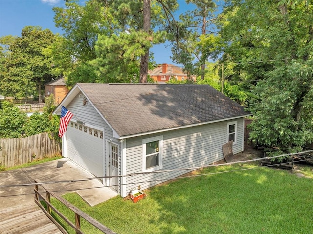 exterior space featuring a garage, a yard, and an outdoor structure