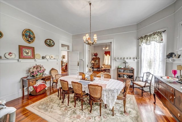 dining space with hardwood / wood-style flooring and an inviting chandelier