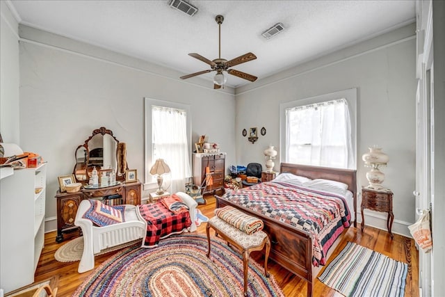 bedroom with ceiling fan, a textured ceiling, and hardwood / wood-style flooring