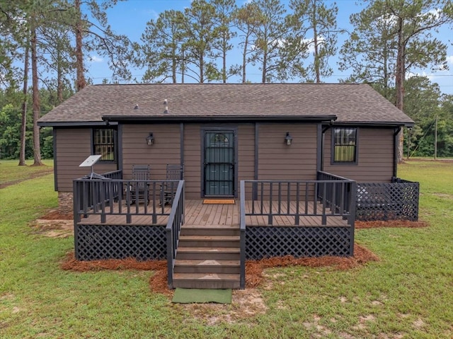 rear view of house with a deck and a lawn