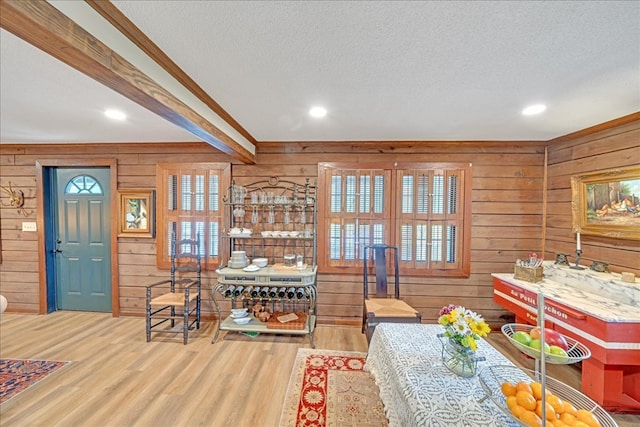 dining room featuring wood walls, hardwood / wood-style flooring, and a textured ceiling