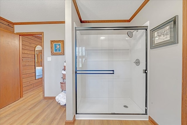 bathroom featuring crown molding, hardwood / wood-style flooring, and a textured ceiling