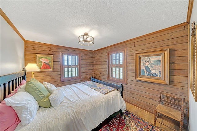 bedroom with hardwood / wood-style flooring, wood walls, and multiple windows