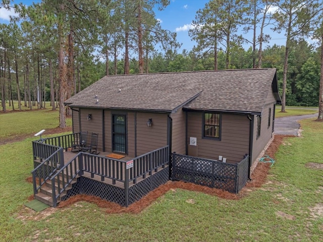 rear view of house with a deck and a lawn