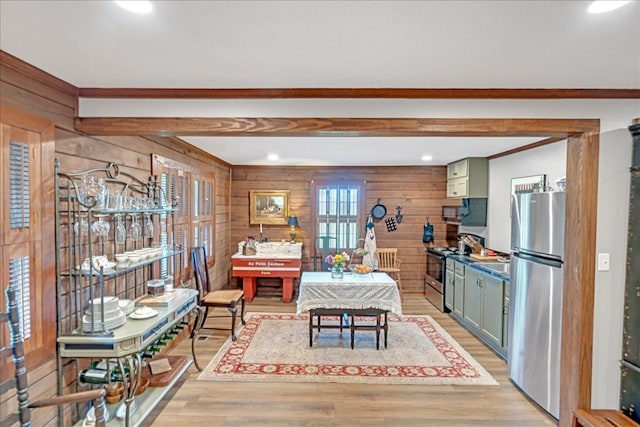 dining room featuring wood walls and light hardwood / wood-style floors