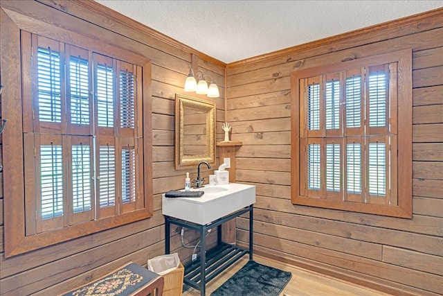 bathroom with a textured ceiling and wood walls