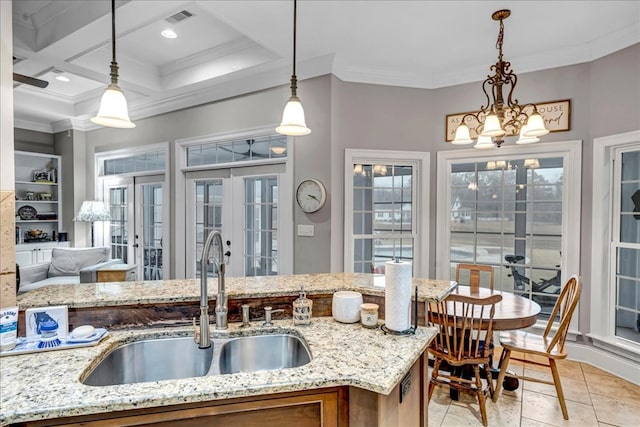 kitchen featuring crown molding, pendant lighting, french doors, sink, and light stone countertops