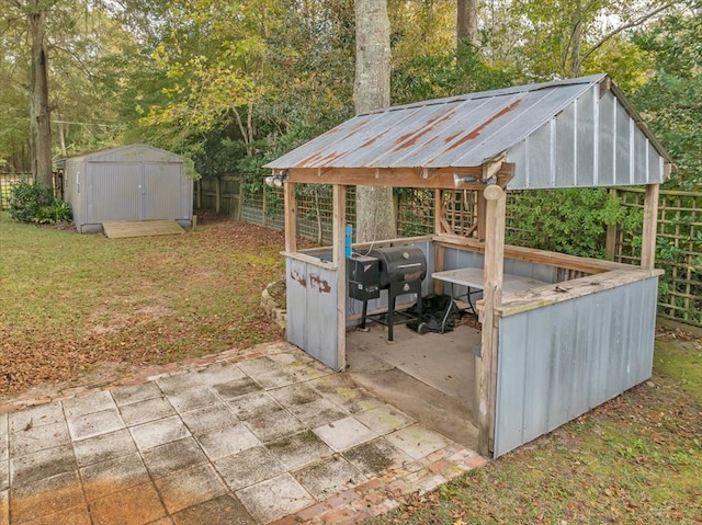 view of patio / terrace featuring a shed and a grill