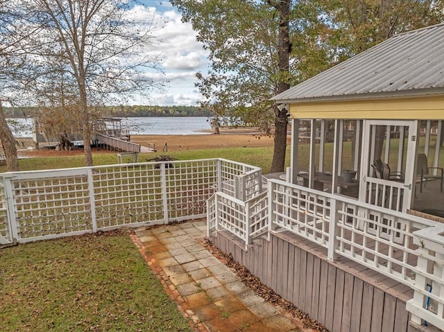 view of yard featuring a sunroom and a water view