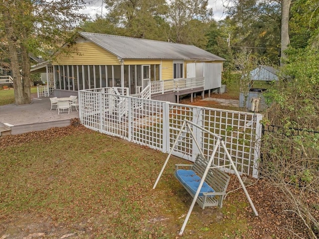 rear view of house with a deck and a sunroom