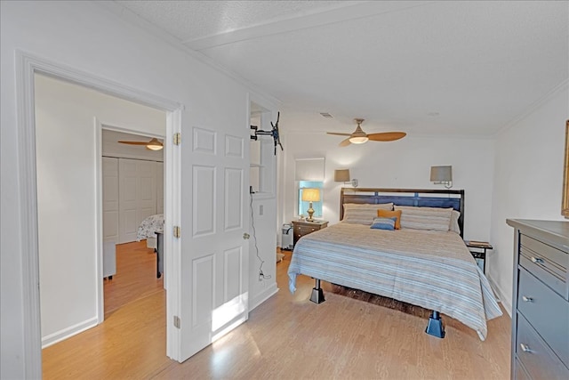 bedroom with ceiling fan, a textured ceiling, and light hardwood / wood-style flooring