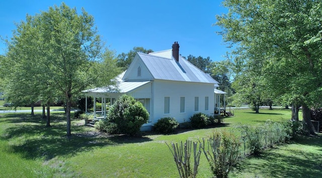 view of home's exterior with a lawn and a porch