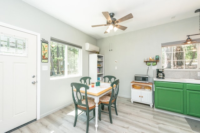 dining area with a wall mounted air conditioner, ceiling fan, and light wood-type flooring