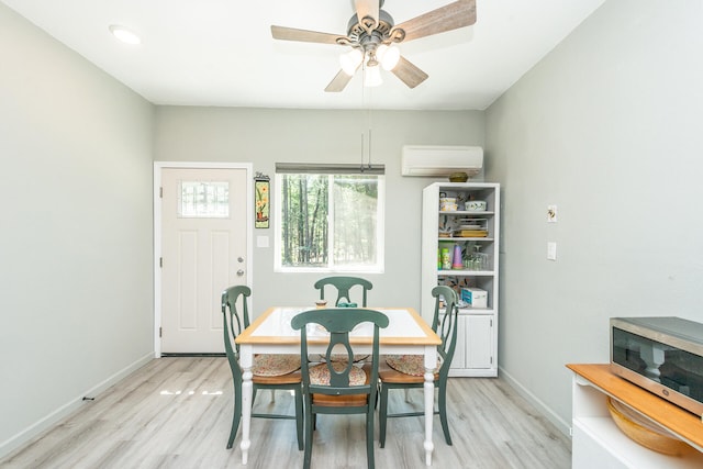 dining room with a wall mounted AC, ceiling fan, and light wood-type flooring