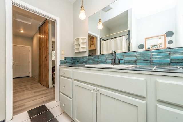 bathroom featuring hardwood / wood-style flooring, backsplash, and oversized vanity