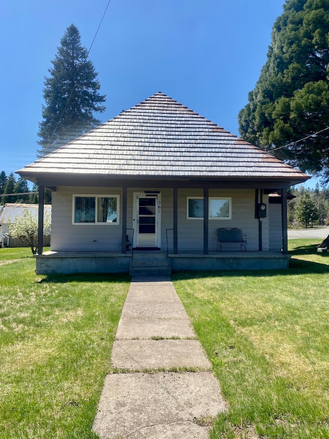 bungalow-style house featuring covered porch and a front yard