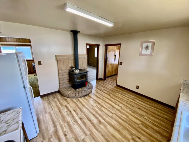 living room featuring a wood stove and light hardwood / wood-style flooring