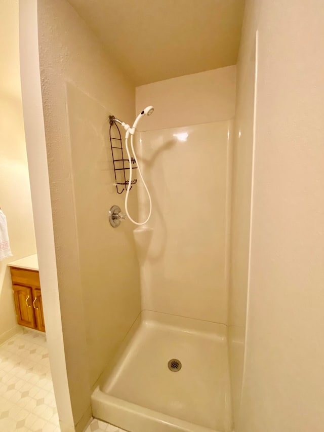 bathroom with walk in shower, tile patterned flooring, and vanity