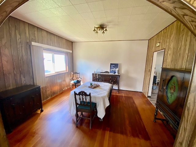 dining space featuring wood-type flooring and wood walls