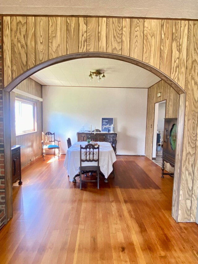 dining room with wooden walls and hardwood / wood-style floors