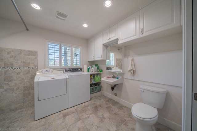 washroom featuring light tile floors, sink, and washing machine and clothes dryer