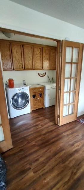 laundry area featuring cabinets, independent washer and dryer, and dark wood-type flooring