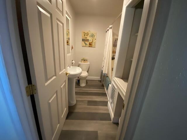 bathroom featuring hardwood / wood-style floors and toilet