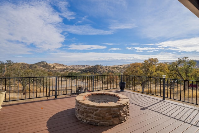 wooden deck with a mountain view and a fire pit