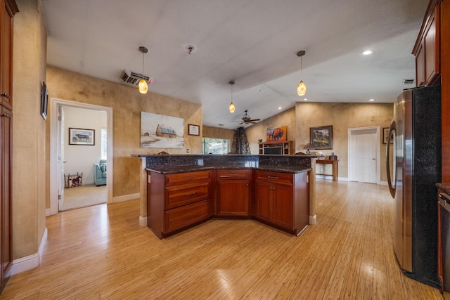 kitchen with hanging light fixtures, stainless steel refrigerator, and a fireplace