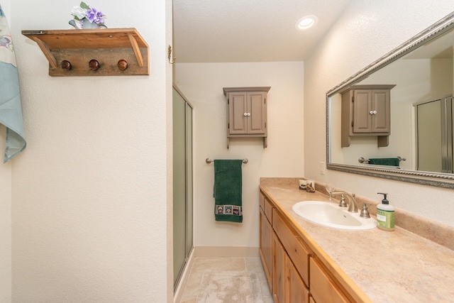 bathroom with tile flooring, large vanity, and walk in shower