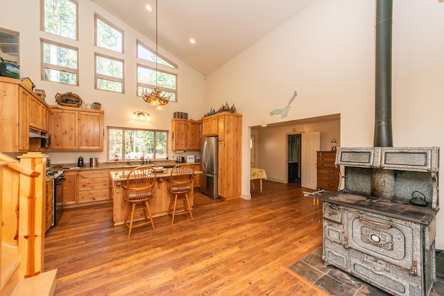 kitchen with electric range oven, high vaulted ceiling, dark wood-type flooring, and stainless steel refrigerator