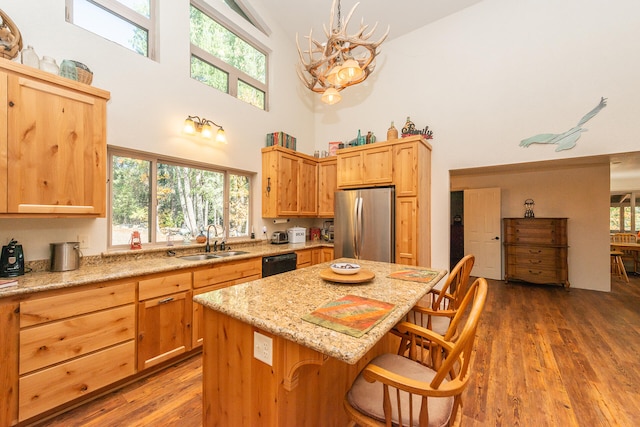 kitchen with stainless steel fridge, a kitchen bar, a chandelier, and dark wood-type flooring