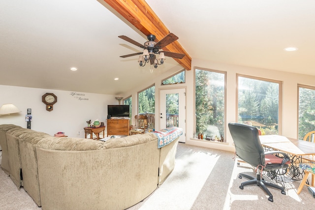 carpeted living room with a healthy amount of sunlight, ceiling fan, and lofted ceiling with beams