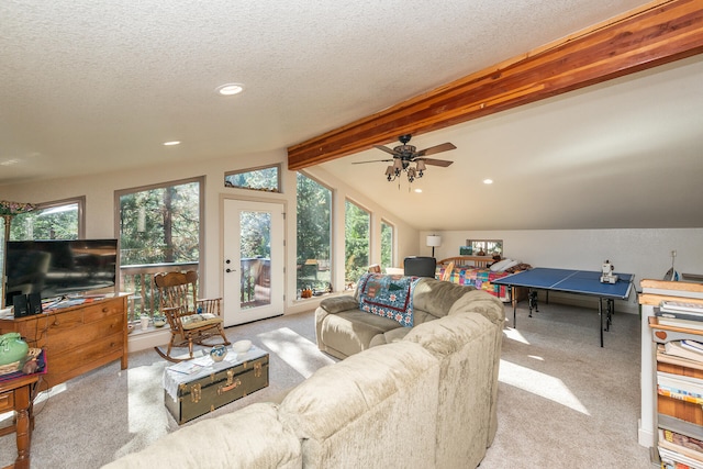 living room featuring plenty of natural light, vaulted ceiling with beams, ceiling fan, and light colored carpet