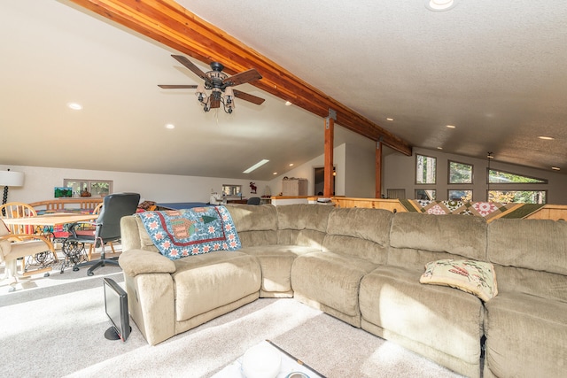 living room with light colored carpet, ceiling fan, vaulted ceiling with beams, and a textured ceiling