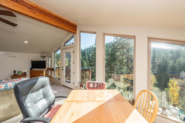 sunroom with plenty of natural light, ceiling fan, vaulted ceiling with beams, and french doors