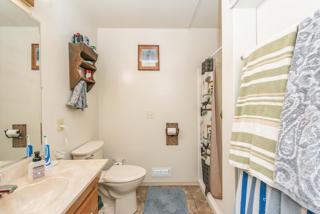 bathroom featuring toilet, large vanity, and tile flooring