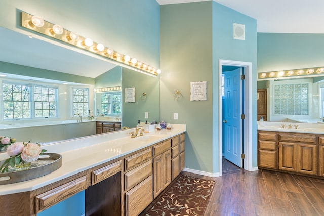 bathroom featuring a bathtub, vanity, hardwood / wood-style flooring, and vaulted ceiling